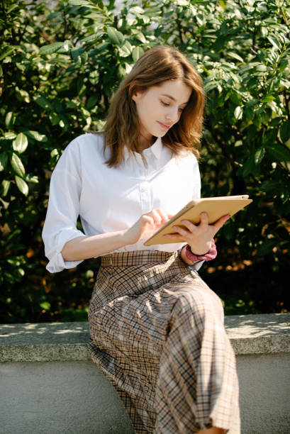 istock Beautiful young student girl using tablet computer, outdoor. 1241712497