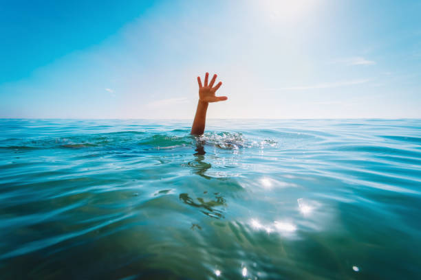 kids water safety concept- child hand see at sea, calling for help stock photo
