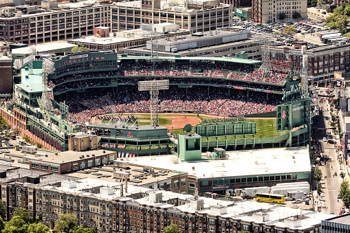 BOSTON, USA - JUNE 10, 2018: The historic architecture of the Fenway Park Stadium from above on a sunny day with a crowed of fans watching a baseball game.