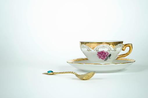 Vintage cup with golden spoon, elements from the Victorian era with handmade decoration.