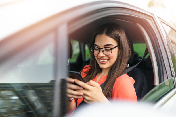 enviando mensajes de texto y conduciendo, al volante. rompiendo la ley. mujer conduciendo coche distraído por su teléfono móvil. mujer escribiendo mensaje en el teléfono mientras espera en el coche. - drunk driving accident teenager fotografías e imágenes de stock