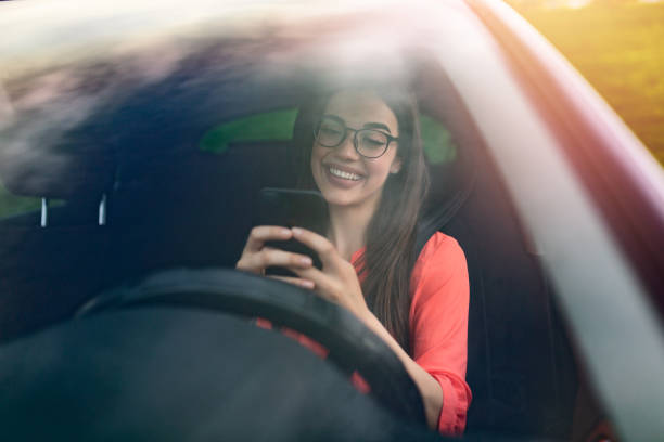 enviando mensajes de texto y conduciendo, al volante. rompiendo la ley. mujer conduciendo coche distraído por su teléfono móvil. mujer escribiendo mensaje en el teléfono mientras espera en el coche. - drunk driving accident teenager fotografías e imágenes de stock