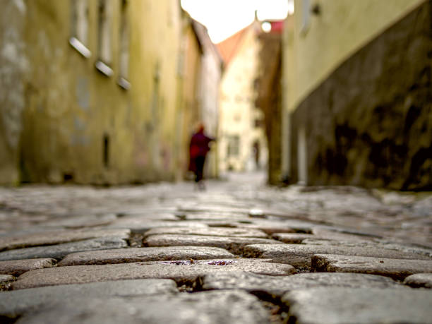 Selectife focus. Street And Old Town Architecture in Tallinn, Estonia. Old stone paved avenue street road. Cobble stones, low angle shot of wet old pavement. filtered or toned image. copy space
