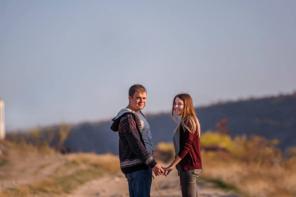 istock Young couple hold hands, smile and look at the camera 1241738992