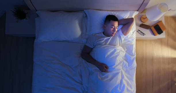asian man sleep well top view of asian man sleep well with smile at night man sleeping top view stock pictures, royalty-free photos & images