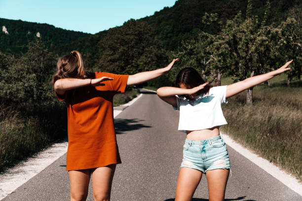Dab Dance Middle of the Road Young Women Performing a DAB Young woman having fun doing a dab dance performance. Posing a DAB side by side together on the middle of a rural road. Youth Culture Girl Friends DAB Lifestyle Portrait. alternative pose photos stock pictures, royalty-free photos & images