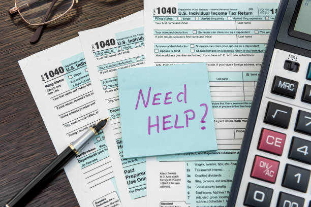 istock Sticker with text Need Help and 1040 tax form, pen and calculator. Deadline 1241783130