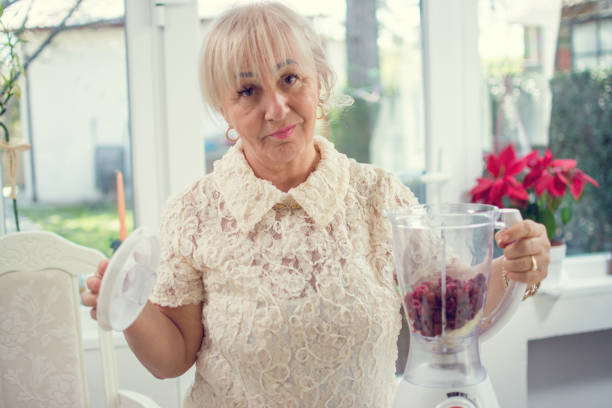 istock Beautiful senior woman preparing smoothie using blender in the kitchen. 1241790762