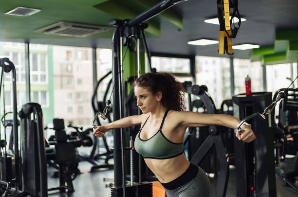istock Young fit woman doing exercise in a crossover exercise machine. Healthy lifestyle concept. Bodybuilding and Fitness 1241791349