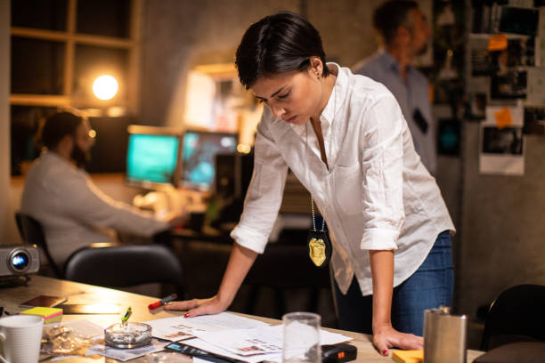 istock Female detective working late at night at office 1241796343