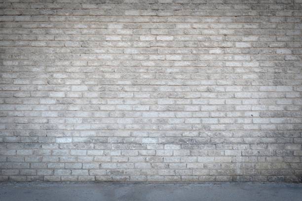 istock Dirty old grungy looking cement brick wall with a pathway running in front of it 1241797930