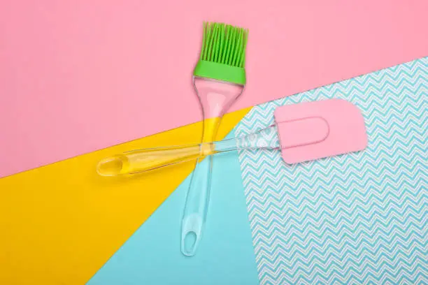 Kitchen spatula and brush on a pastel background. Top view
