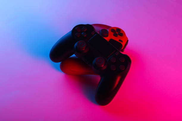 istock Two Gamepads with neon blue-pink light. Gaming concept. 1241812084