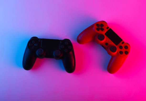 istock Two Gamepads with neon blue-pink light. Gaming concept. 1241812285