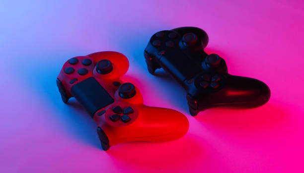 istock Two Gamepads with neon blue-pink light. Gaming concept. 1241812652