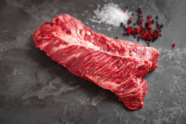 Hanging Tender steak on a stone background with salt and pepper - steak tab Hanging Tender steak on a stone background with salt and pepper - onglet steak flank steak stock pictures, royalty-free photos & images