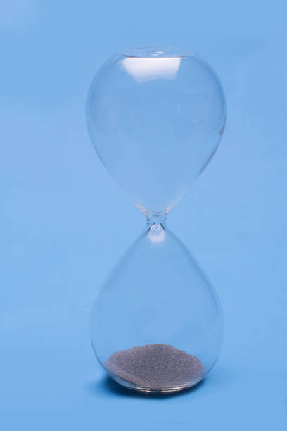 istock Hour glass on a blue backgrrounf 1241821447
