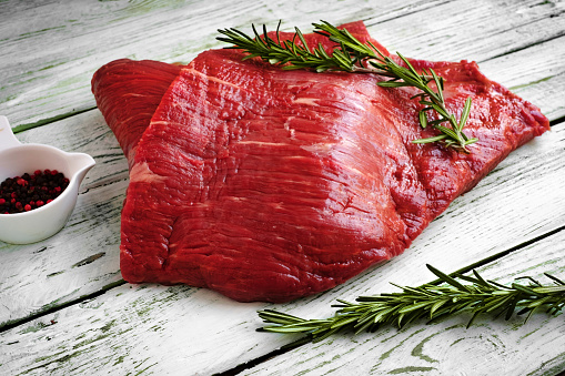 raw fillet of beef brisket on white wooden background