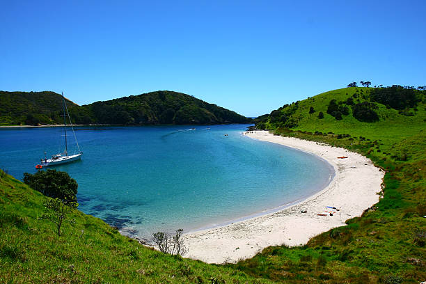 Bay of islands in New Zealand with a boat on the water lonely bay in the Bay of Islands in New Zealand bay of islands new zealand stock pictures, royalty-free photos & images