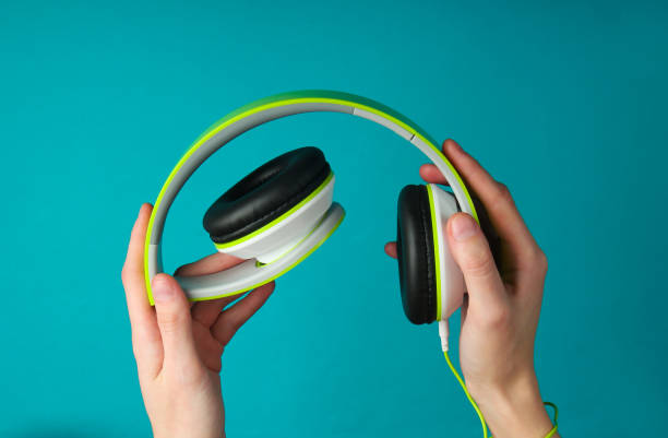 istock Female hands fold folding stereo headphones on a blue background 1241847491