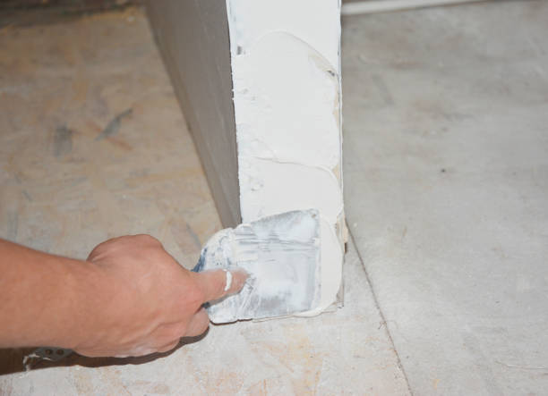 istock Skim coating the outside corner covering the angle bead with a compound using taping knife. 1241851455