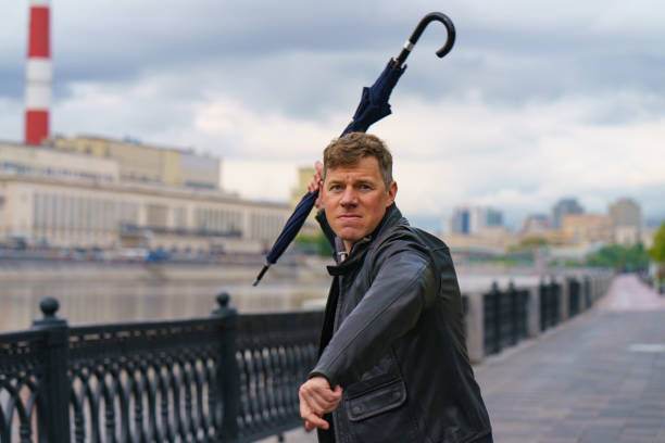 istock Agressive man attackong with umbrella 1241853160