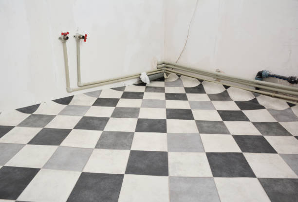 Kitchen renovation with linoleum flooring, tile effect vinyl flooring, and installed plastic water pipes for hot and cold water.