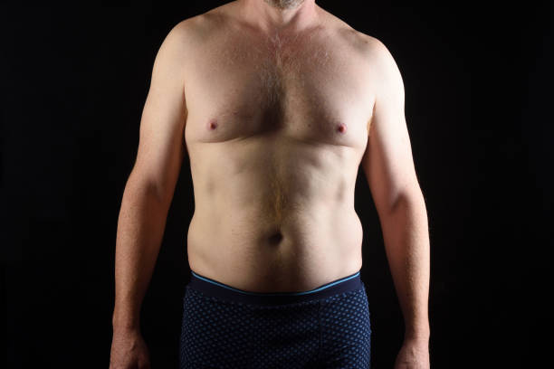 Portrait of a middle aged man body of a real man man on black background, front view low body fat stock pictures, royalty-free photos & images