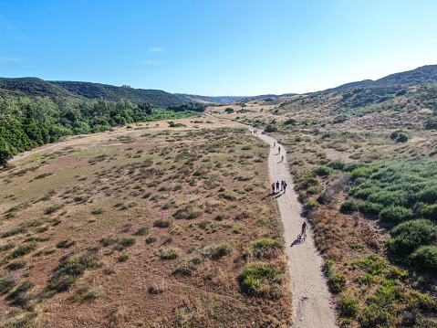 Aerial view of Los Penasquitos Canyon Preserve with tourists, hikers and bikers on the trails,. Urban park with mountain, forest and trails in San Diego, California. USA