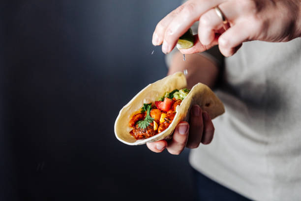 female hand squeezing lime into vegan tacos - healthy eating portion onion lunch imagens e fotografias de stock