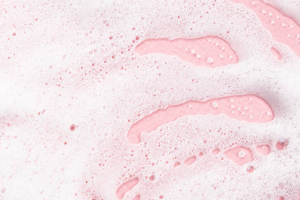 istock White soapy foam on a pink background. 1241884486