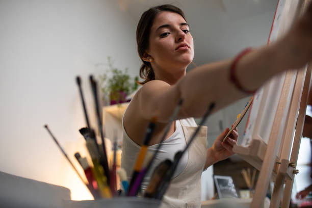 istock A young woman reaching for a brush while painting 1241895122