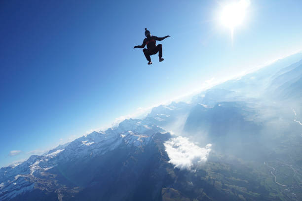 istock Skydiver falls through clear skies, aerial flight 1241918786