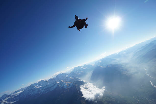istock Skydiver falls through clear skies, aerial flight 1241918797