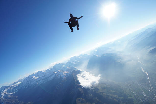 istock Skydiver falls through clear skies, aerial flight 1241921472