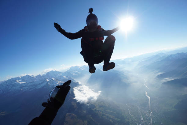 istock Skydivers fall through clear skies, aerial flight 1241925179