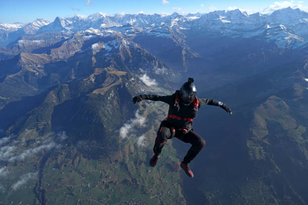 istock Skydiver falls through clear skies, aerial flight 1241927829