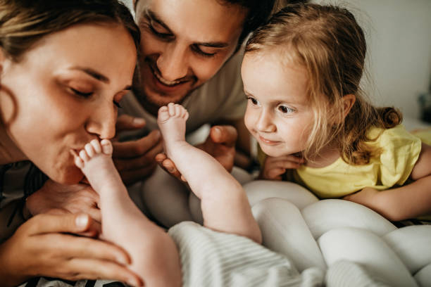 We are cute family Family playing with new baby member in bed parent stock pictures, royalty-free photos & images