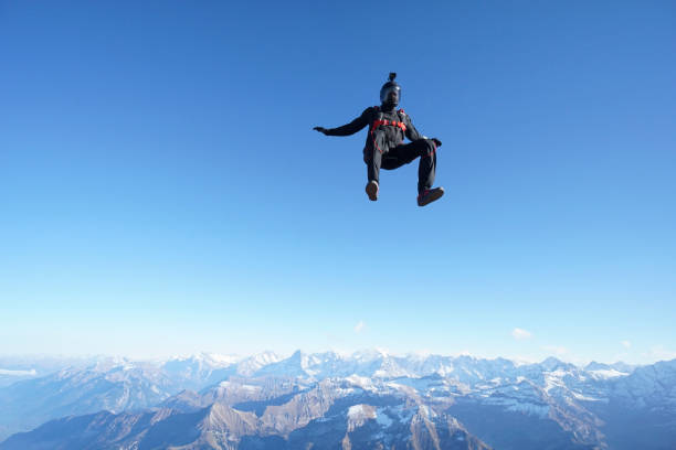 istock Skydiver falls through clear skies, aerial flight 1241929470