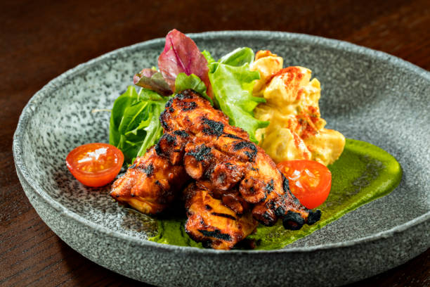 istock Fried Grilled octopus with salad and salsa sauce on a round plate, close up. 1241931043