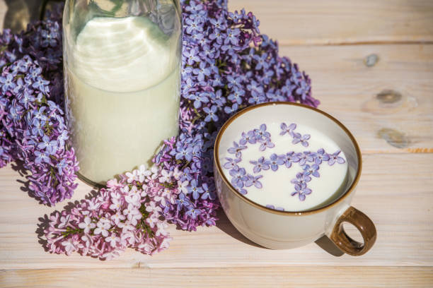 istock Cup with milk and small purple lilac flowers 1241932091