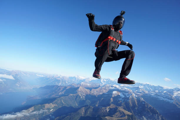 skydiver falls through clear skies, aerial flight - mountain drop europe switzerland imagens e fotografias de stock