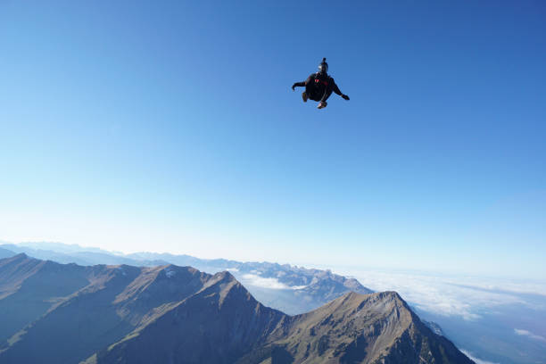 istock Skydiver falls through clear skies, aerial flight 1241942766