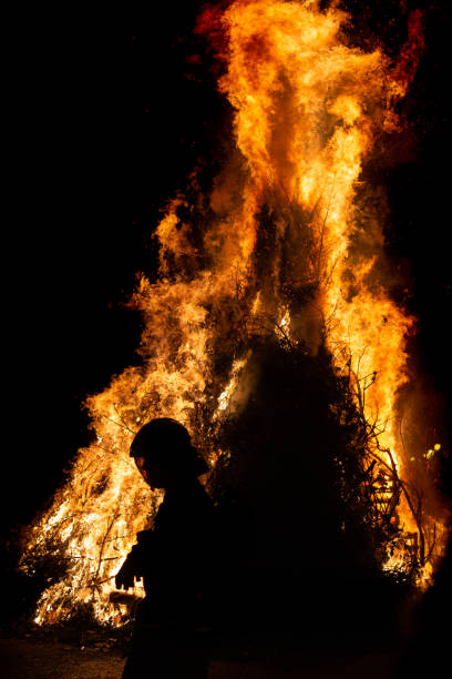 istock Impressive bonfire with firefighter in the foreground 1241945817