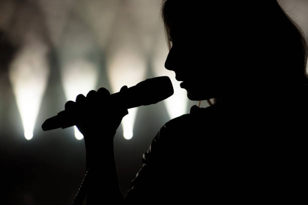 istock Singer in silhouette. Close up image of live singer on stage 1241945837