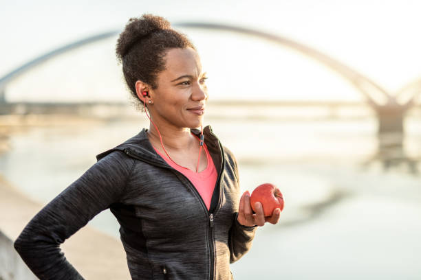 sporty woman se encarga de su salud. - apple healthy eating eating black fotografías e imágenes de stock