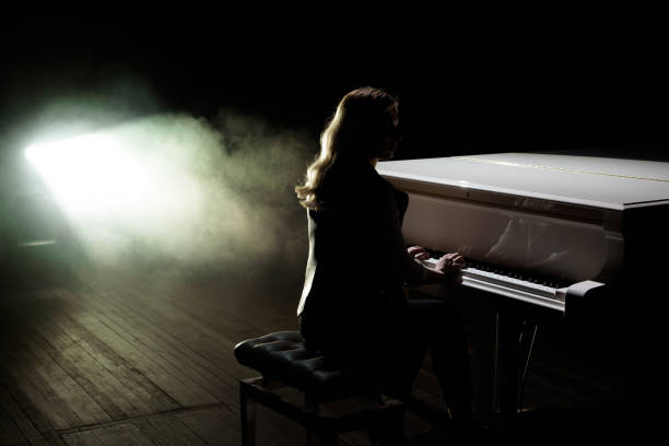 istock Female keyboards player on stage during concert, backlight 1241947564