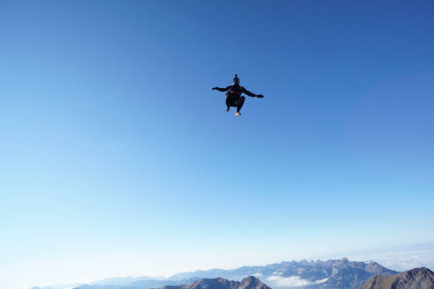 istock Skydiver falls through clear skies, aerial flight 1241949739