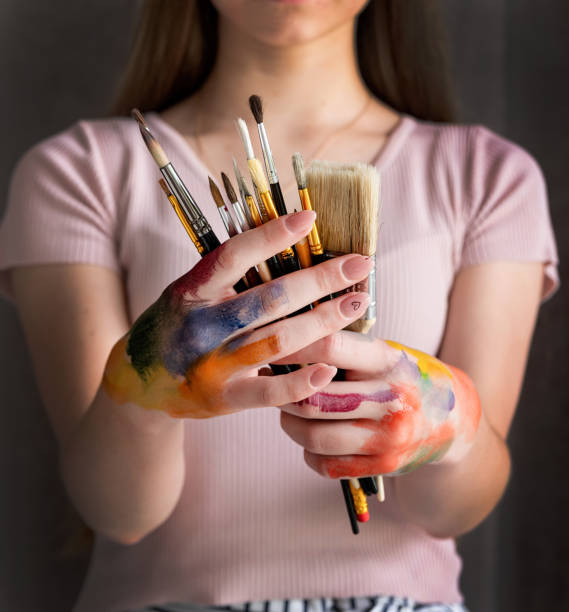istock female artist hands holding paintbrushes 1241955467
