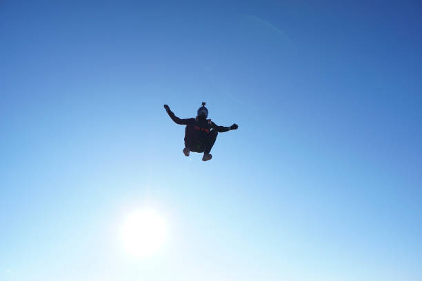 istock Skydiver falls through clear skies, aerial flight 1241956242